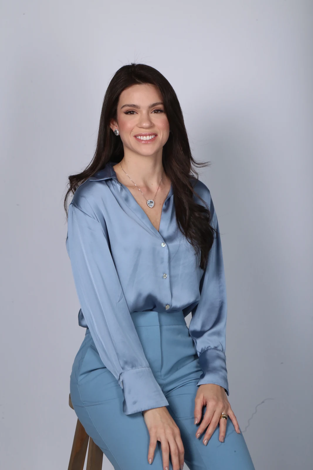 Dra. Sarha Andrade em retrato profissional, vestindo azul
